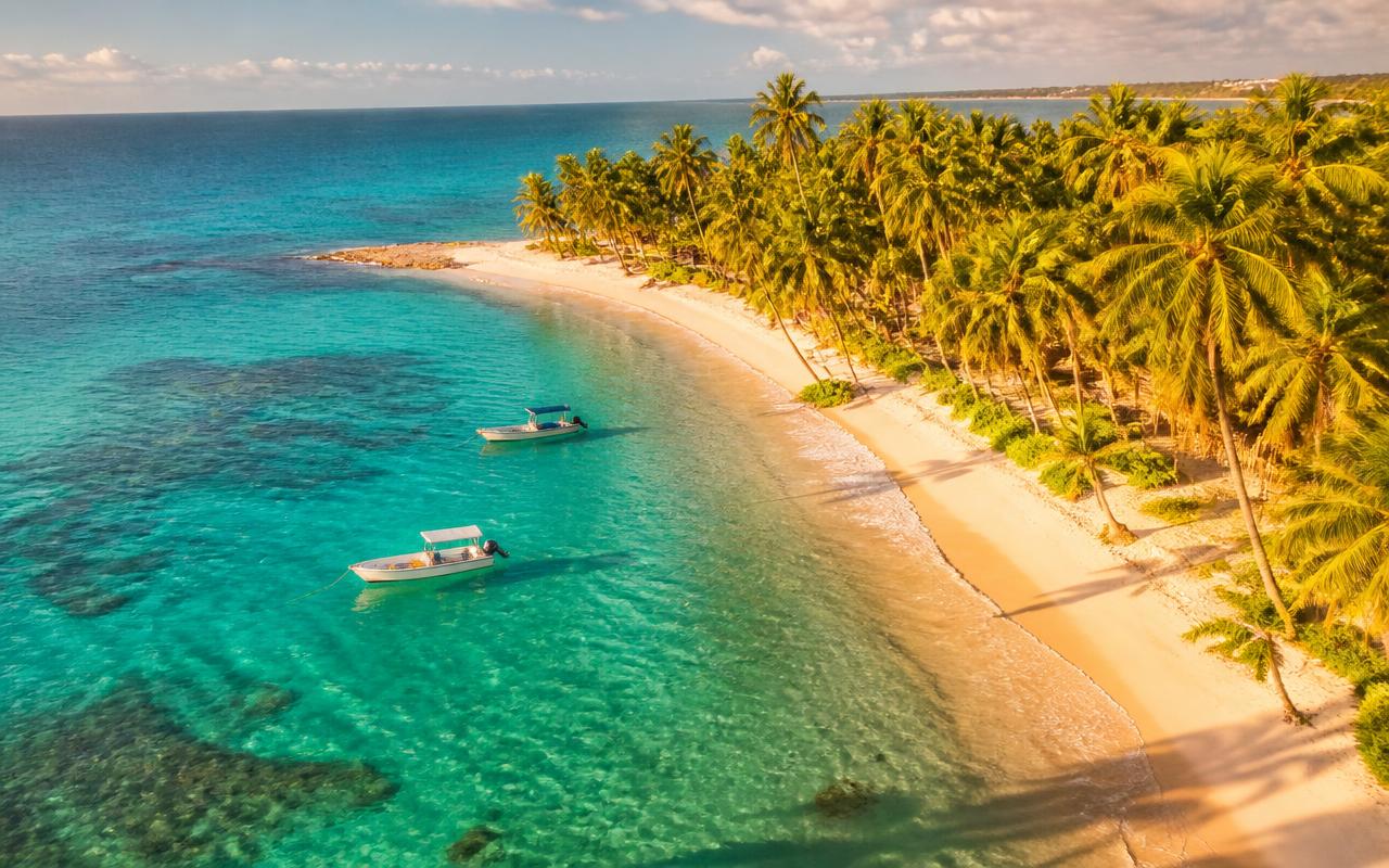Praia de águas turquesa no Nordeste brasileiro vista de cima no fim da tarde